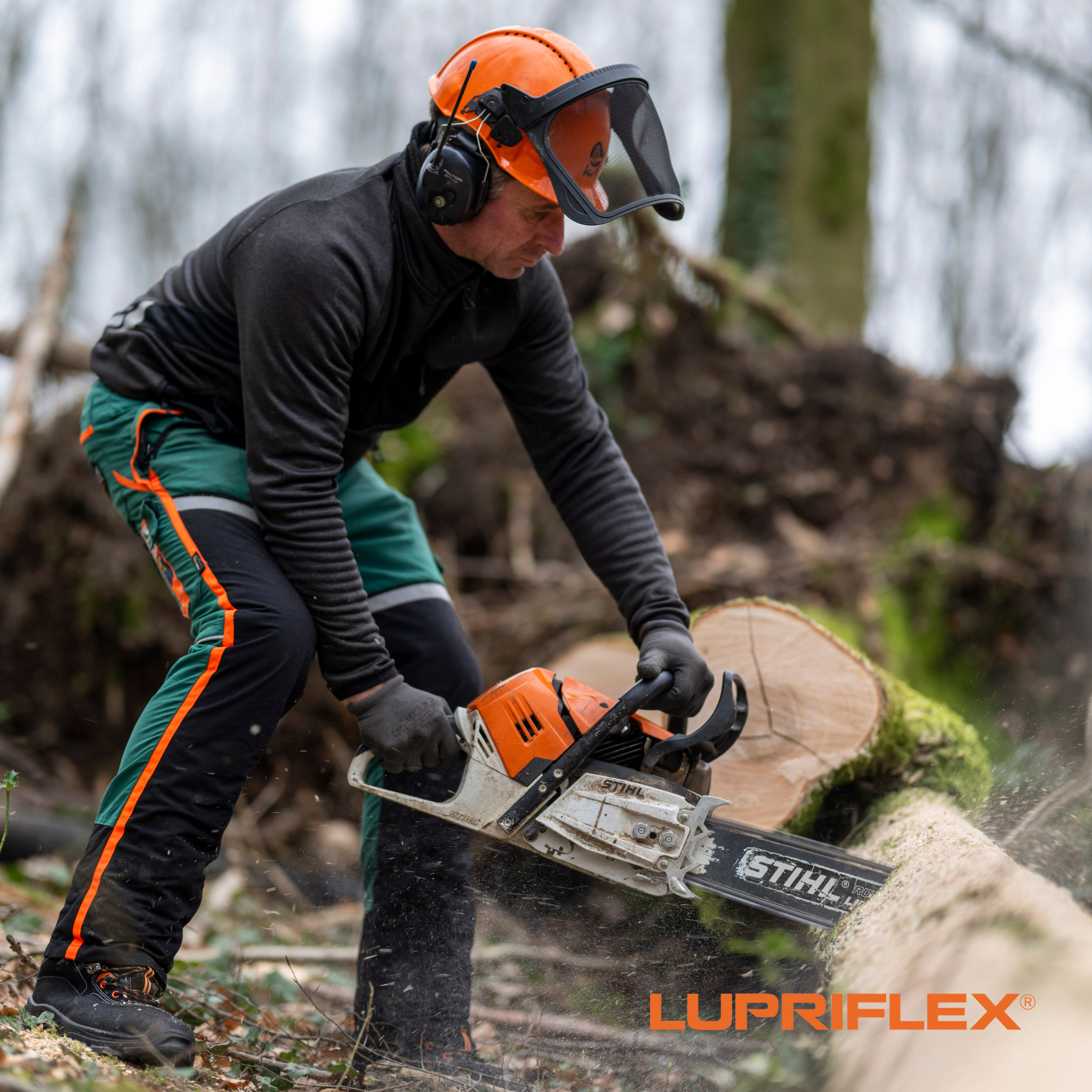 Forstwirt mit Lupriflex Schnittschutzstiefeln beim Kleinsaegen eines Baumstammsmsaegen mit 